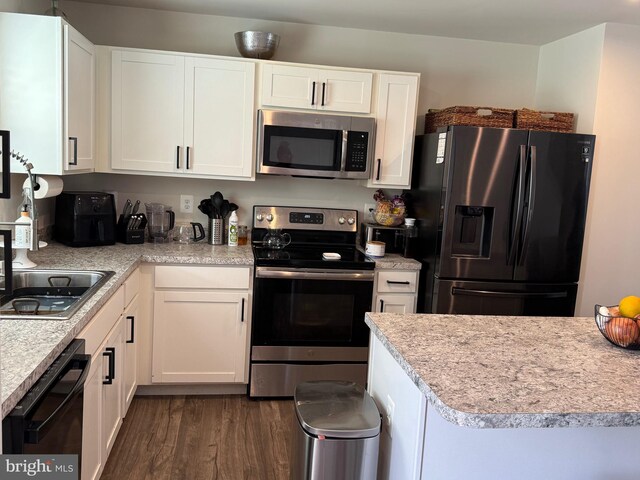 kitchen featuring white cabinets, black appliances, and dark wood-style floors