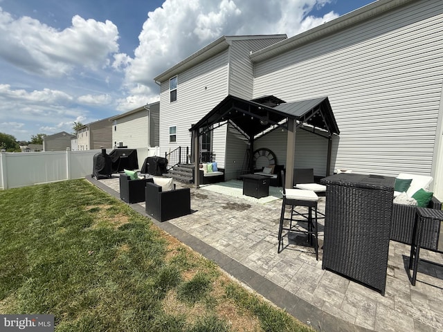rear view of house with outdoor lounge area, fence, a patio, a gazebo, and a yard