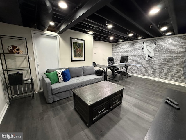 living area featuring dark wood-style flooring, baseboards, and brick wall
