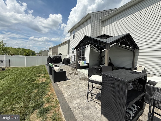 view of patio featuring a gazebo, an outdoor living space, and fence