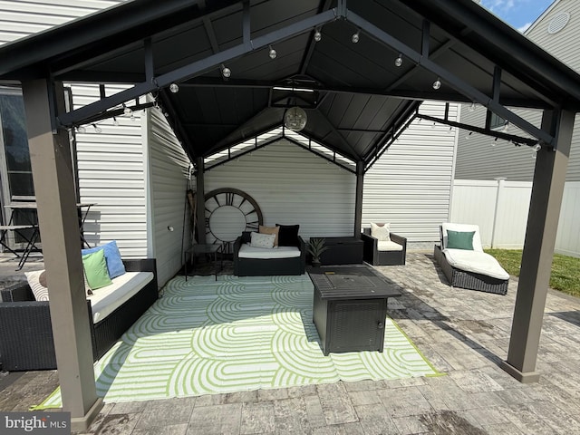 view of patio / terrace featuring an outdoor living space, fence, and a gazebo
