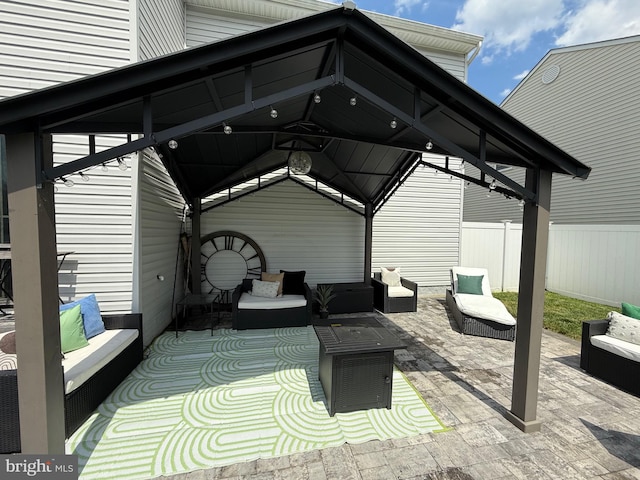 view of patio / terrace with an outdoor hangout area, fence, and a gazebo
