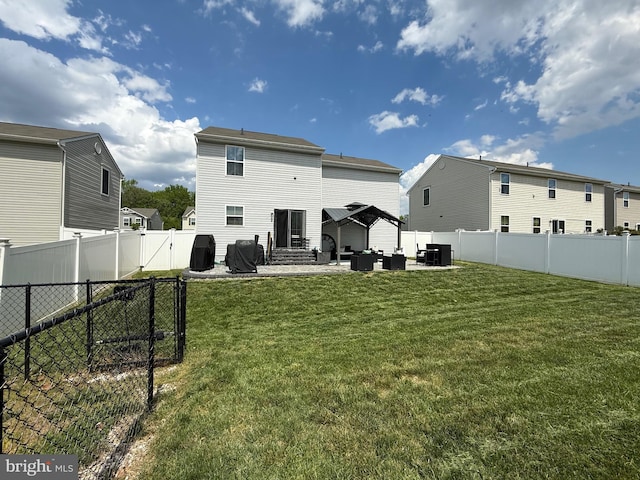back of house featuring a yard, a fenced backyard, entry steps, and an outdoor hangout area