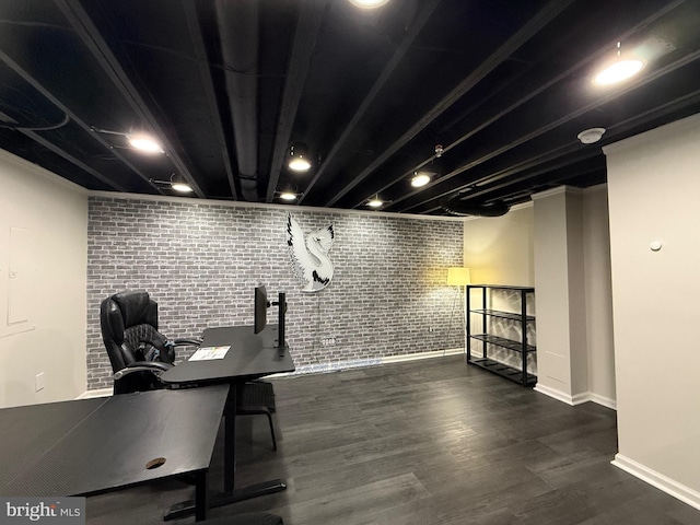 office area with baseboards, wood finished floors, and brick wall