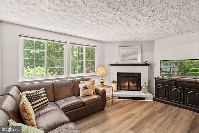 8337 Wind Fall Rd, Springfield, VA 22153 - living room featuring a textured ceiling, wood finished floors, and a brick fireplace