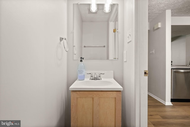 8337 Wind Fall Rd, Springfield, VA 22153 - bathroom featuring wood finished floors, vanity, baseboards, and a textured ceiling