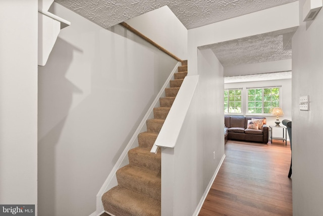 8337 Wind Fall Rd, Springfield, VA 22153 - stairs with wood finished floors, a textured ceiling, and baseboards