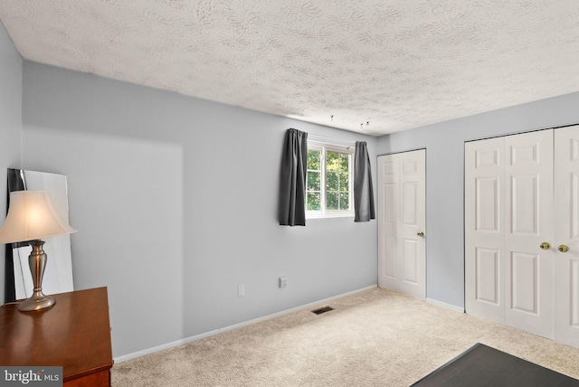8337 Wind Fall Rd, Springfield, VA 22153 - unfurnished bedroom featuring carpet floors, a textured ceiling, baseboards, and multiple closets