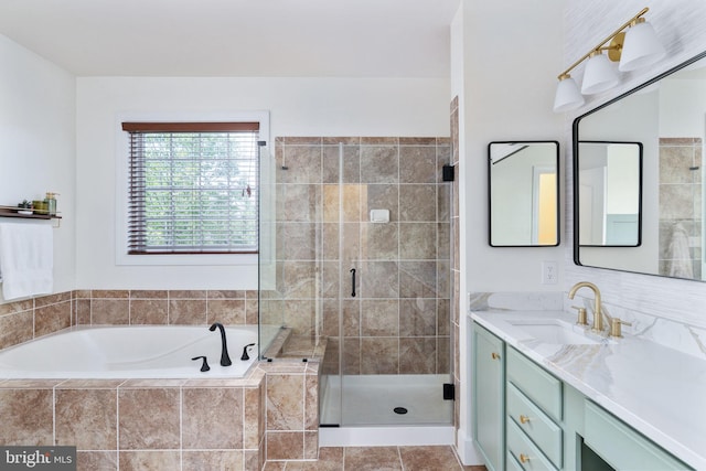 bathroom featuring a shower stall, a garden tub, and vanity