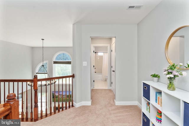 corridor featuring light carpet and baseboards