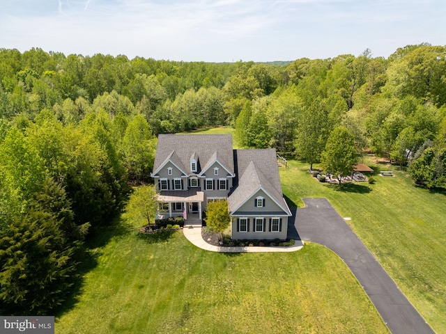 aerial view of property and surrounding area with a heavily wooded area