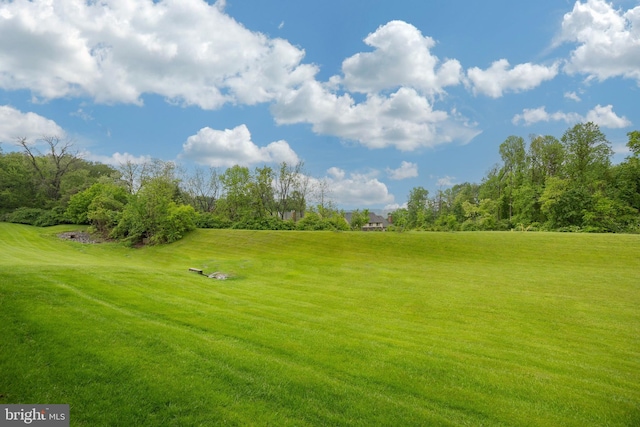 surrounding community with golf course view and a lawn