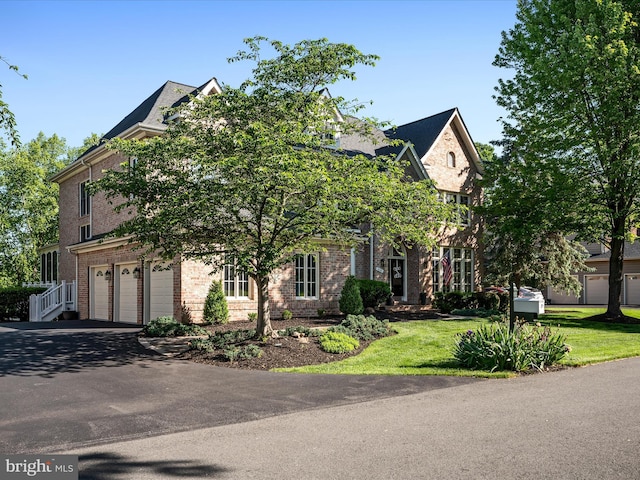 view of front of home with brick siding, an attached garage, and driveway