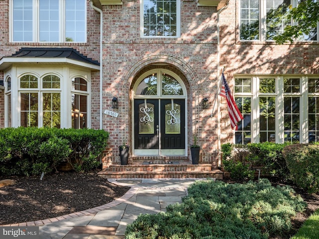 view of exterior entry with brick siding