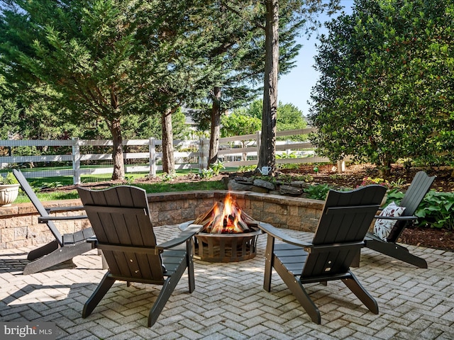 view of patio featuring an outdoor fire pit and fence