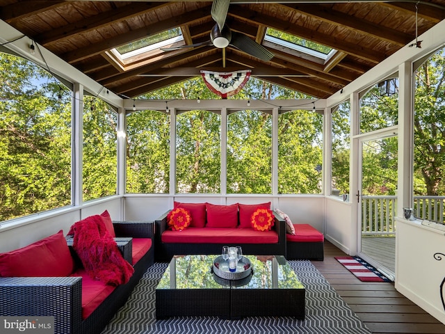 sunroom featuring a skylight, vaulted ceiling, outdoor lounge area, and plenty of natural light