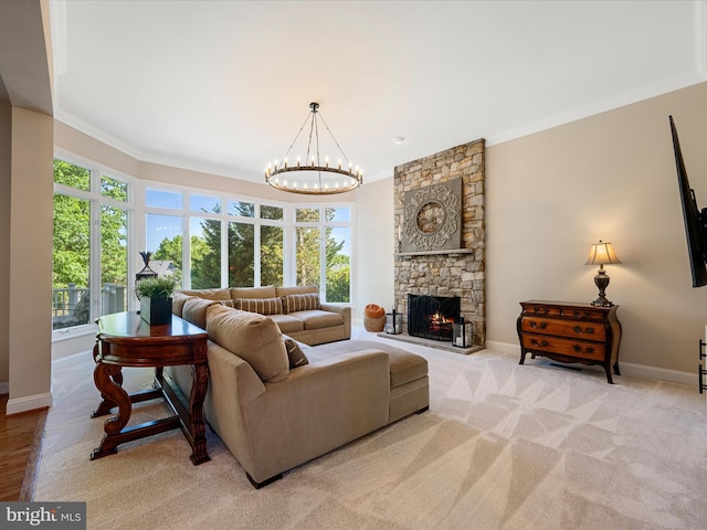 carpeted living area featuring ornamental molding, baseboards, a chandelier, and a stone fireplace