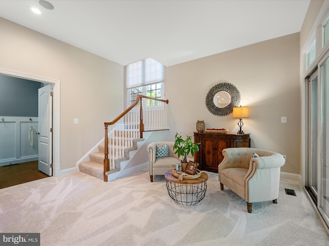 living area with carpet floors, stairway, and baseboards