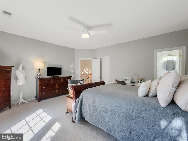 bedroom featuring light carpet, baseboards, a chandelier, a ceiling fan, and ensuite bathroom