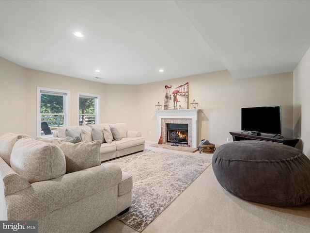 living room with recessed lighting and a warm lit fireplace