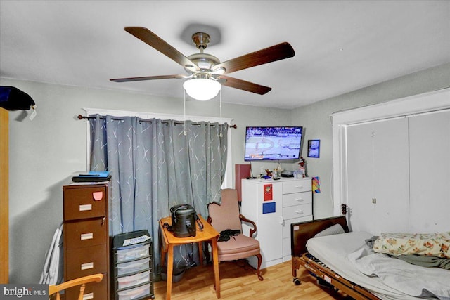 bedroom featuring a ceiling fan, a closet, and wood finished floors