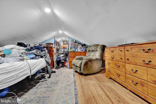 bedroom with light wood finished floors and vaulted ceiling