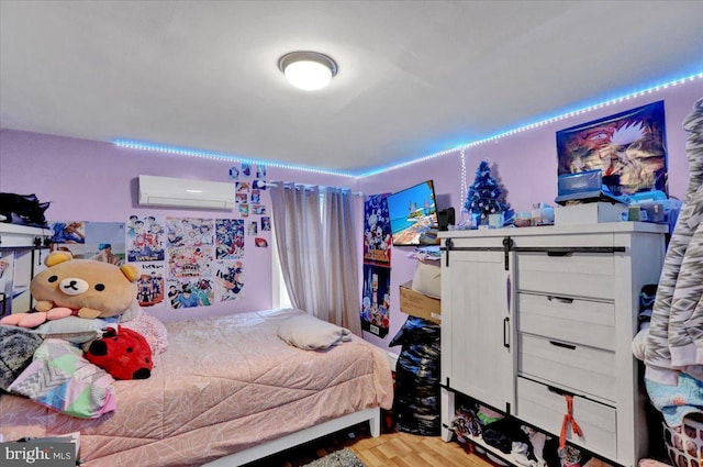 bedroom with an AC wall unit and light wood-type flooring