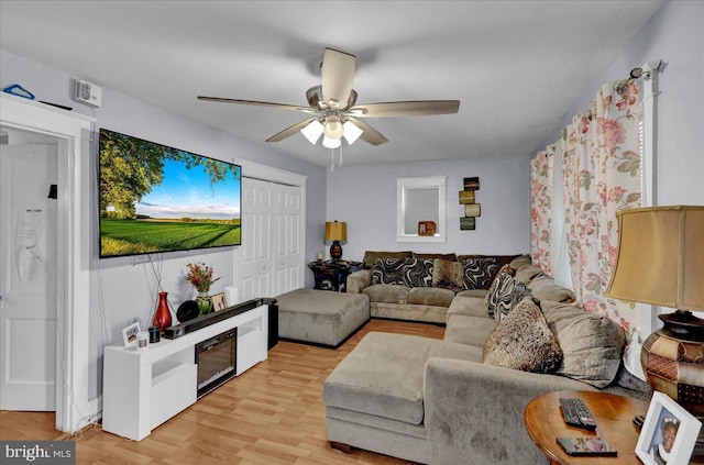 living area with light wood finished floors and a ceiling fan