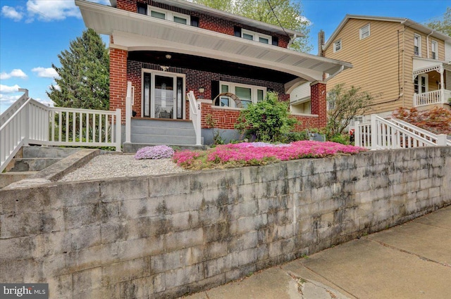 view of front of home with covered porch and brick siding