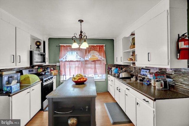kitchen featuring open shelves, dark countertops, white cabinetry, stainless steel microwave, and gas stove
