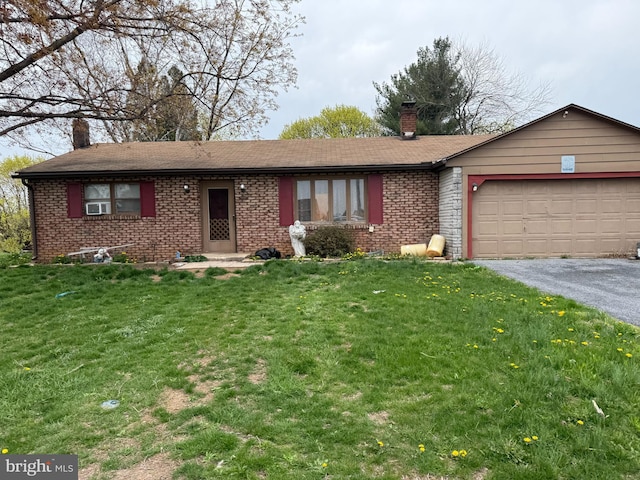 single story home with a garage, a front lawn, aphalt driveway, a chimney, and brick siding