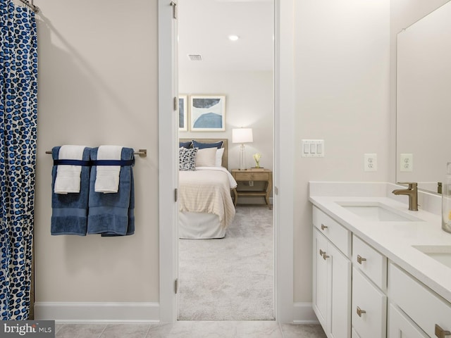 full bathroom with a sink, ensuite bath, double vanity, baseboards, and visible vents