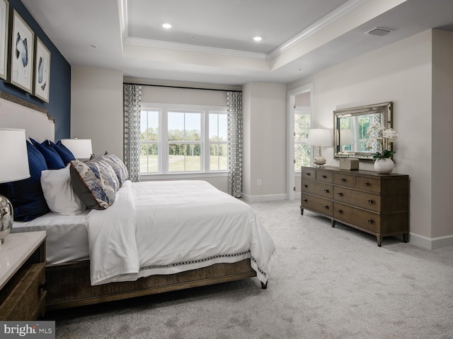 carpeted bedroom with a tray ceiling, visible vents, ornamental molding, and baseboards