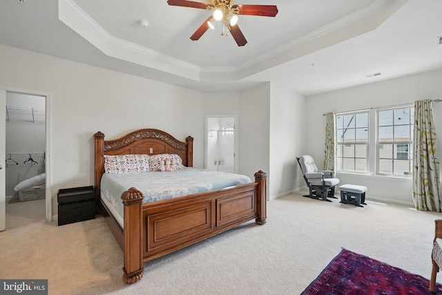 bedroom with crown molding, a tray ceiling, light colored carpet, and visible vents