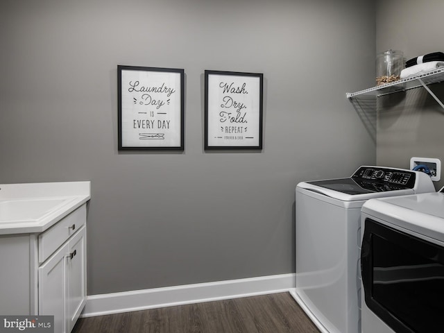 clothes washing area with washer and dryer, dark wood-style flooring, cabinet space, a sink, and baseboards