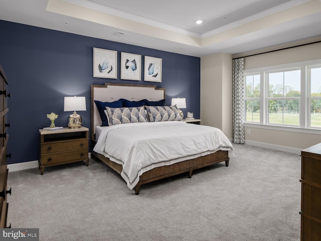 bedroom with carpet floors, ornamental molding, visible vents, baseboards, and a raised ceiling