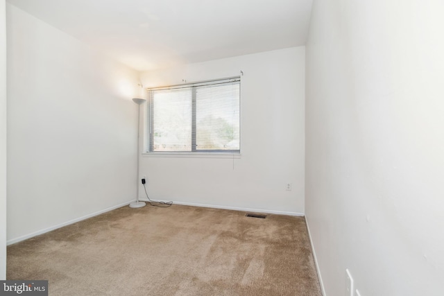 unfurnished room with carpet floors, baseboards, and visible vents