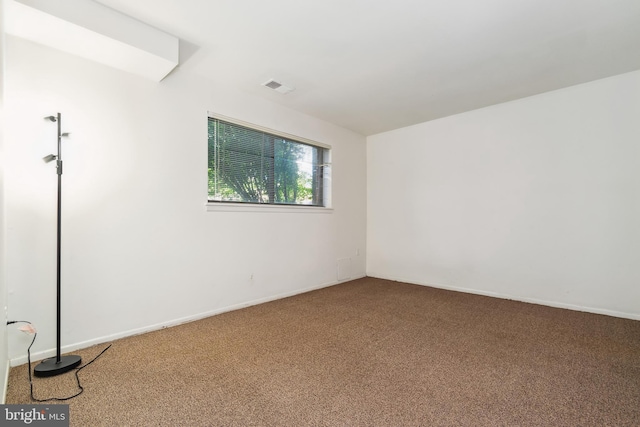 carpeted spare room featuring visible vents