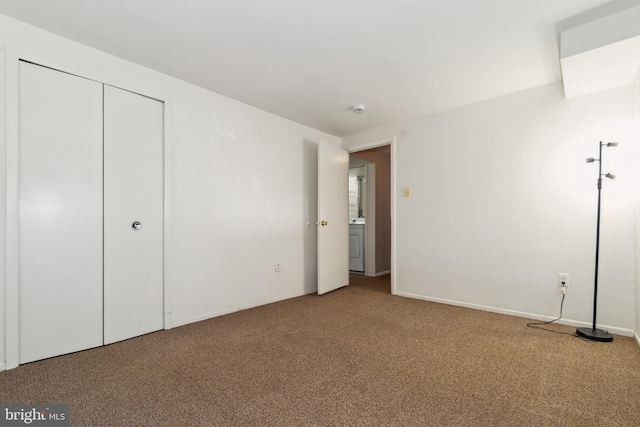 unfurnished bedroom with washer / clothes dryer, carpet, and a closet