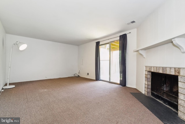unfurnished living room with carpet floors, a brick fireplace, and visible vents