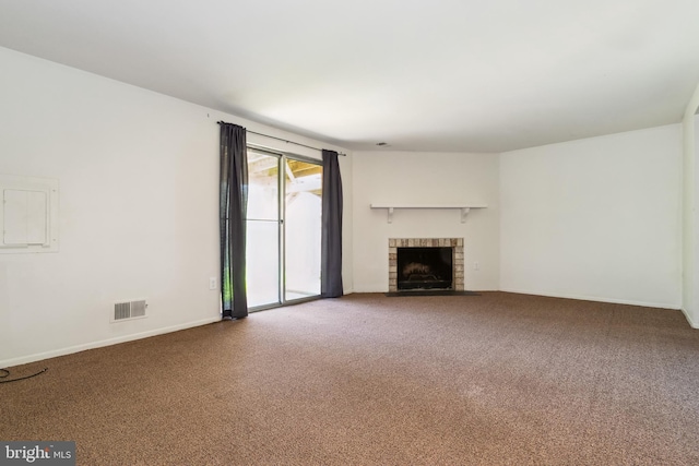 unfurnished living room with carpet flooring, baseboards, visible vents, and a brick fireplace