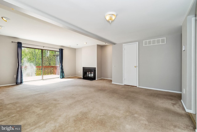 unfurnished living room with visible vents, carpet flooring, a multi sided fireplace, and baseboards