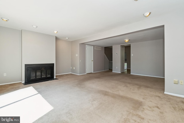 unfurnished living room with carpet floors, baseboards, and visible vents