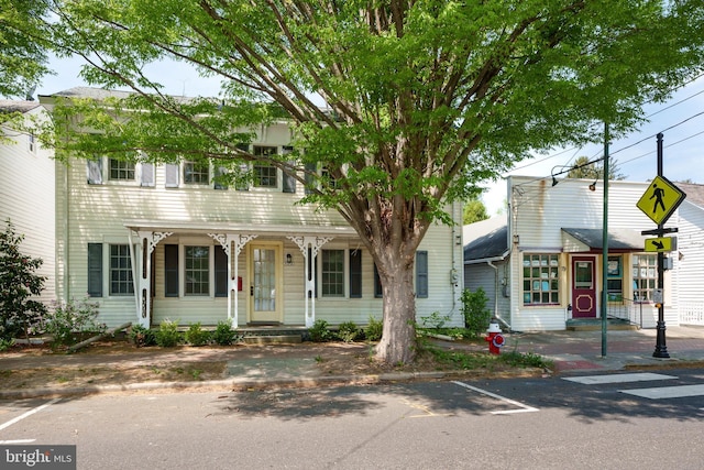 view of front of house with covered porch and uncovered parking