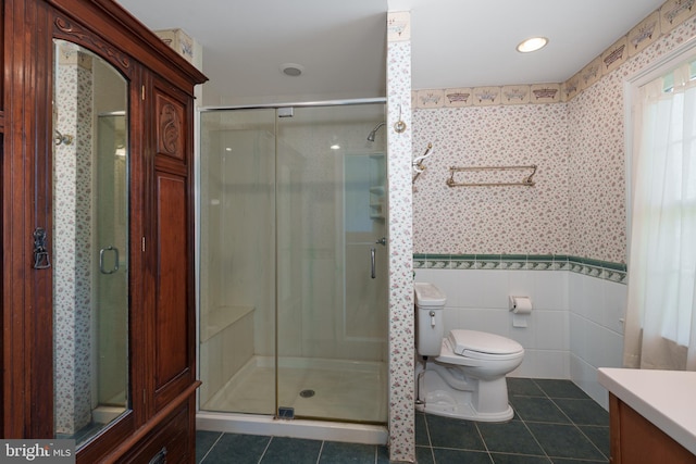 bathroom featuring toilet, tile patterned floors, wallpapered walls, and a shower stall