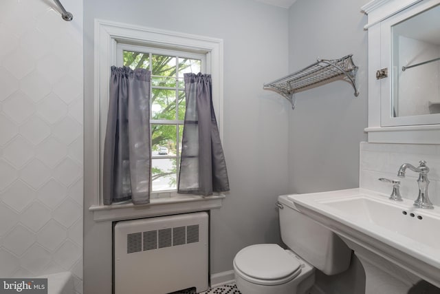 full bath featuring walk in shower, a sink, baseboards, toilet, and radiator heating unit