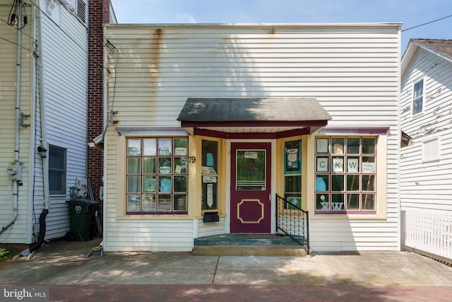 doorway to property featuring roof with shingles