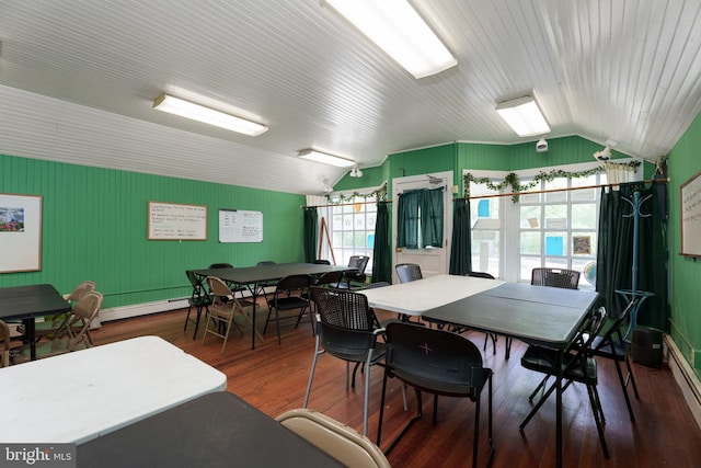 dining space featuring vaulted ceiling and wood finished floors