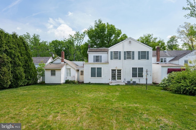 view of front of house featuring central AC unit, entry steps, and a front lawn