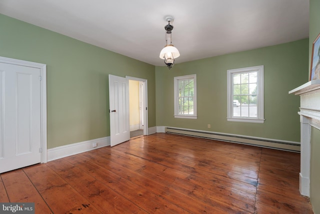 unfurnished dining area featuring wood-type flooring, baseboards, a fireplace, and a baseboard radiator